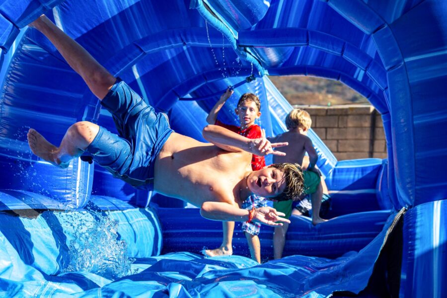 boy jumping sideways while going down a water slide,